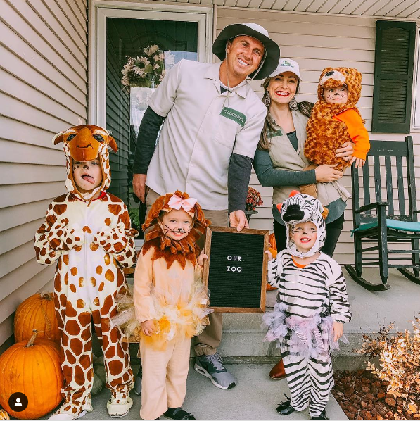 A family dressed in Zoo Animal themed Halloween costumes, featuring Zoo Keepers, a giraffe, a lion, a zebra, and a bear.