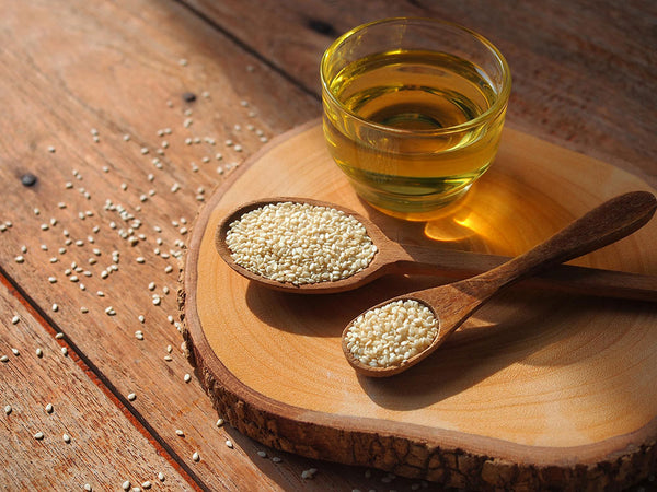white-sesame-seeds-wooden-spoon-glass-sesame-oil-healthy-food-concept