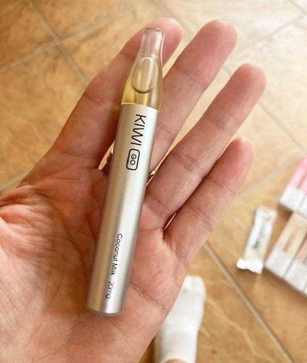 A Kiwi GO disposable vape held in a hand