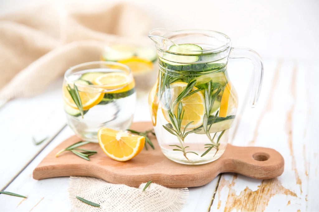 Lemons in glass jugs with herbs