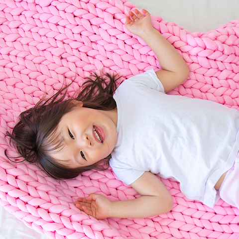 Child playing on weighted blanket