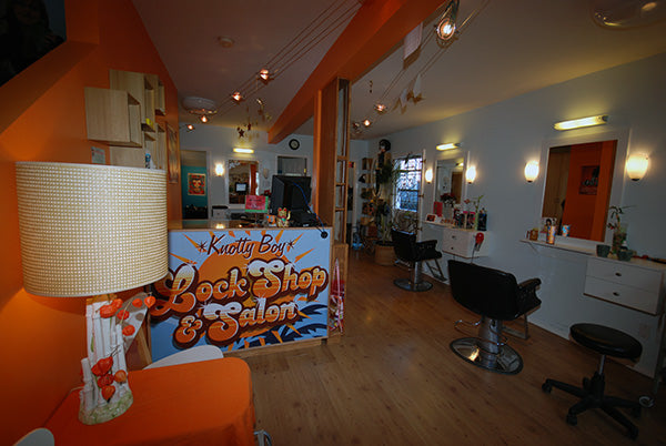 interior of orange highlighted salon with wood floors  and three stylst stations