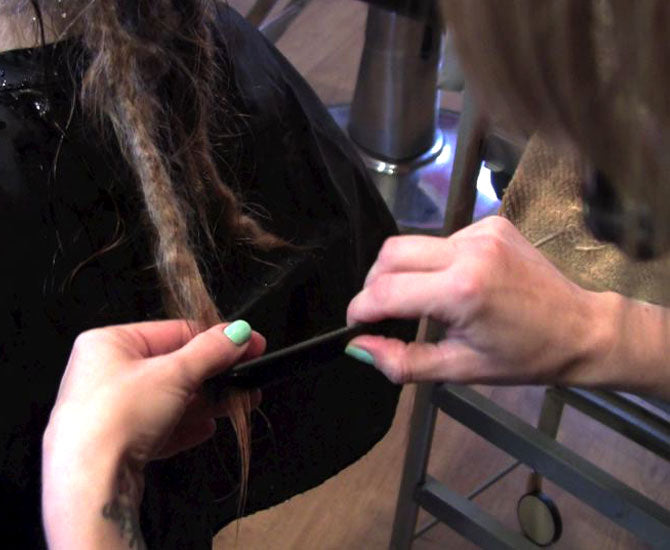 combing out a half-inch or one centimetre dreadlock from the bottom