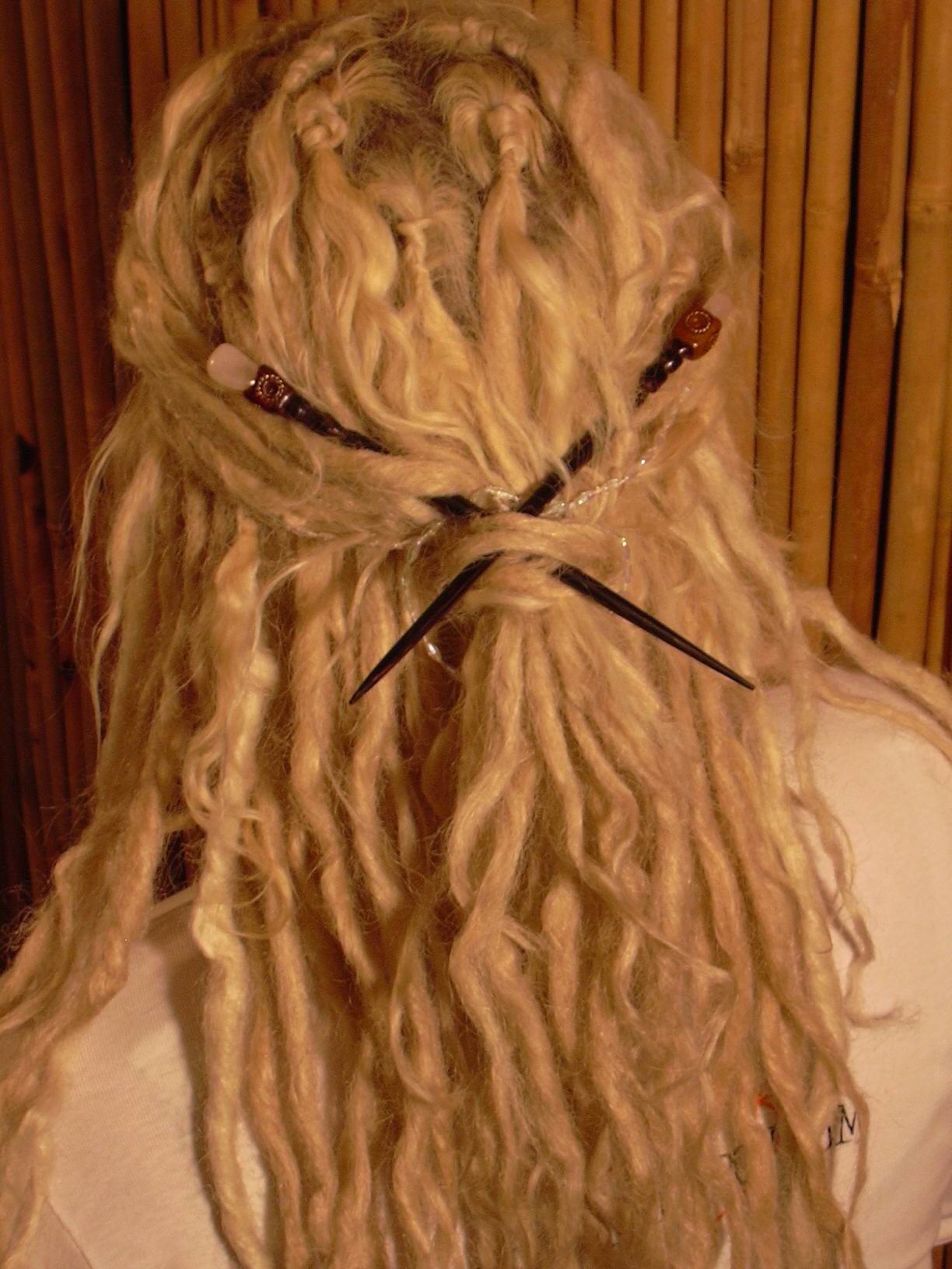 rear view of dreadlock style tied with chopsticks to create a swept back look