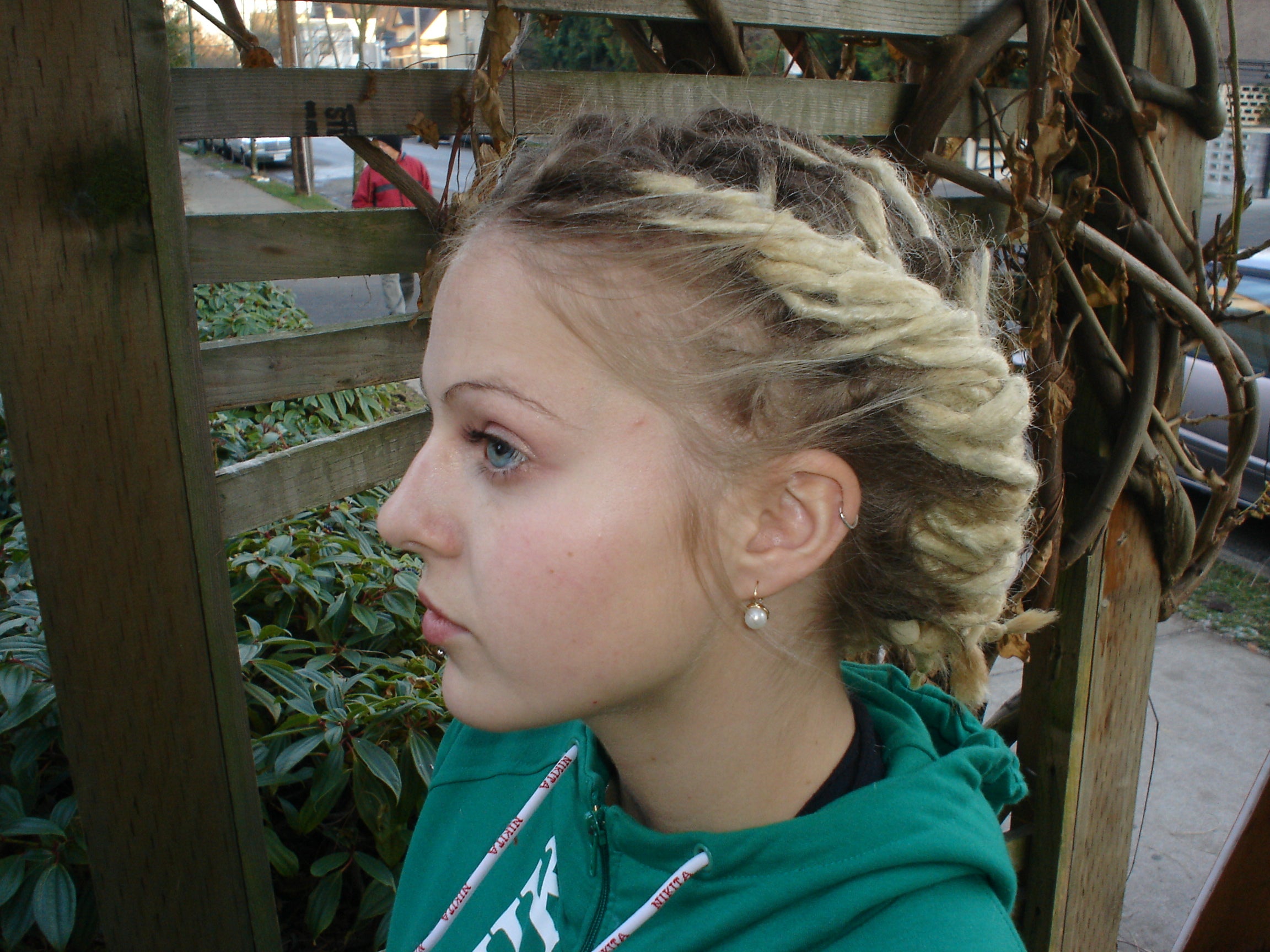 woman with two tightly braided ridges of dreadlocks on her head both starting in front and continuing to nape of her neck