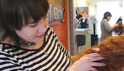 closeup of Becca, locktician stylist at former Knotty Boy salon sectioning hair preparatory to dreadlocking