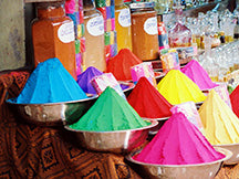 piled up brightly coloured spices in bowls on display at a market in India