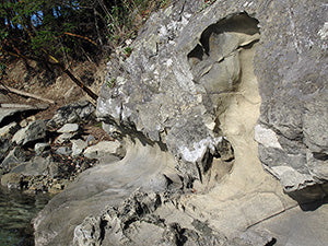 water-worn grey rocks on the shore in full sunlight