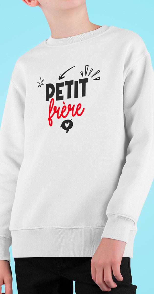 Souriant jeune garçon portant fièrement son pull "Petit Frère"