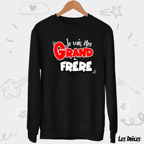 Détail du message "Je vais être Grand Frère" sur le pull, tissu doux en gros plan