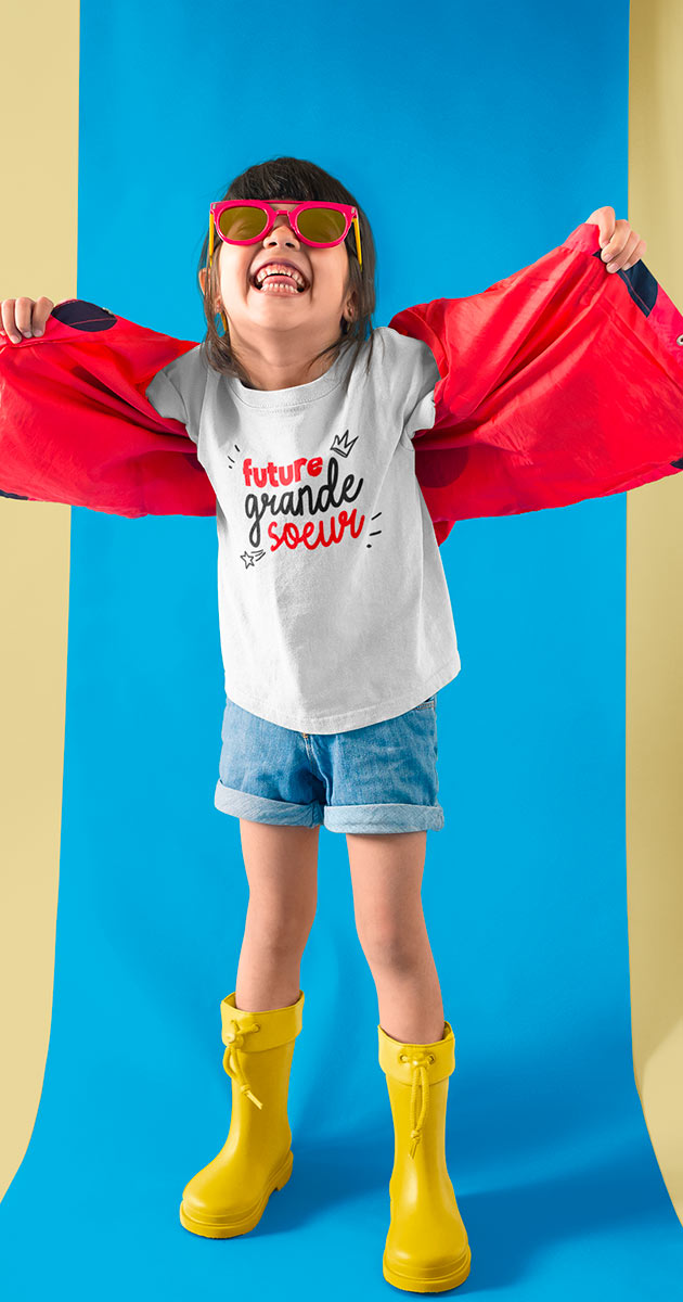 Petite fille souriante portant le T-shirt "Future grande sœur"