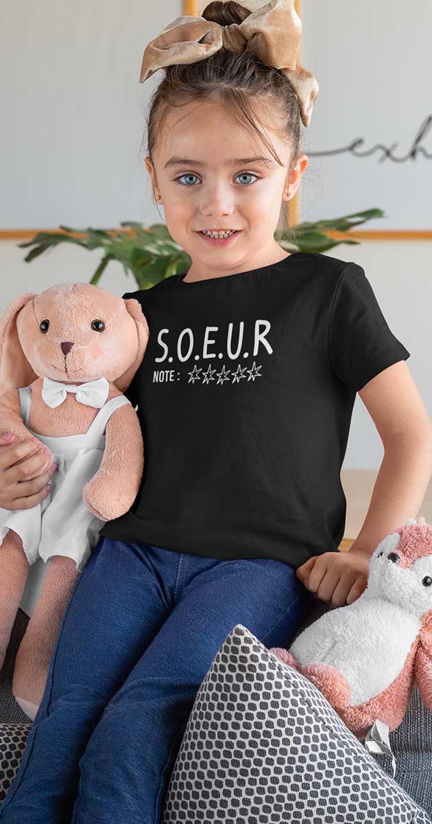 Jeune fille souriante arborant fièrement son t-shirt "Sœur 5 étoiles