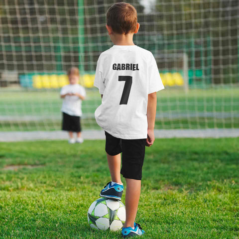 jeune garcon qui joue au football avec son t-shirt personnalisé