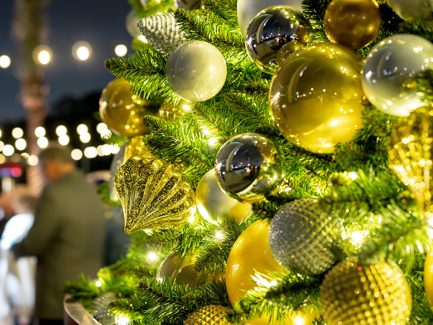 Whimsical and elegant, a Christmas tree decked out in gold, white, and silver ornaments evokes feelings of nostalgia and wonder.