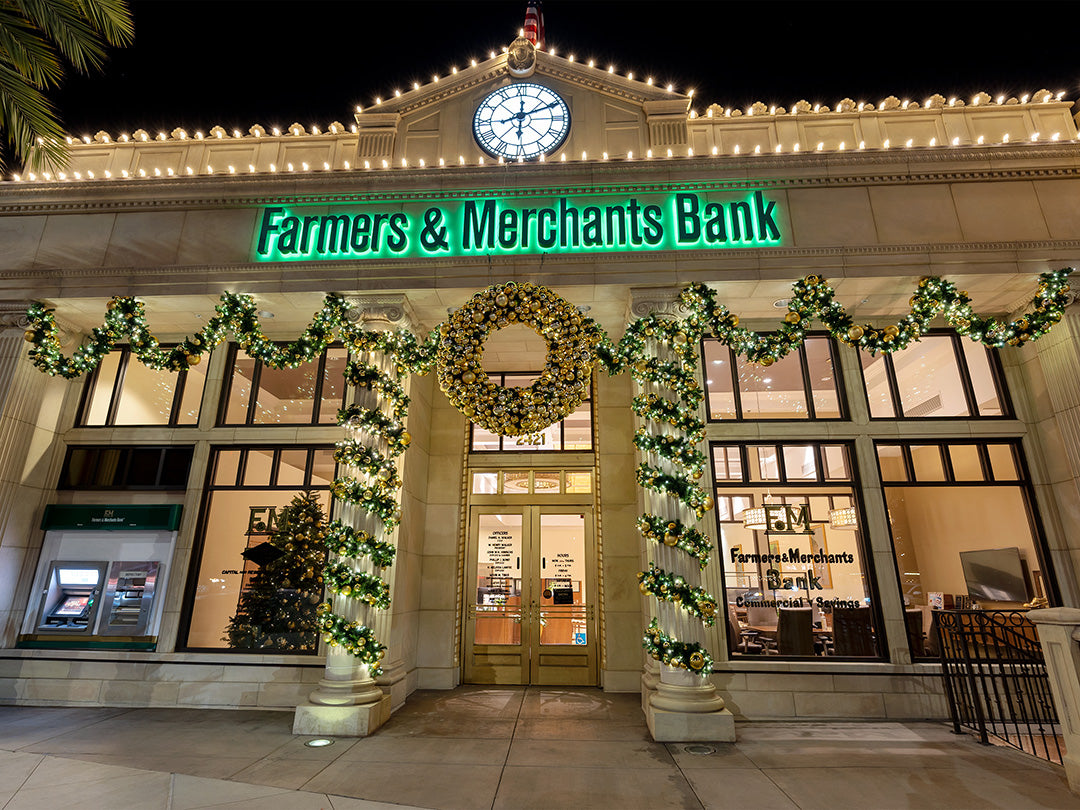 A festive Farmers and Merchants Bank decorated for Christmas with a wreath and garland above the entrance.