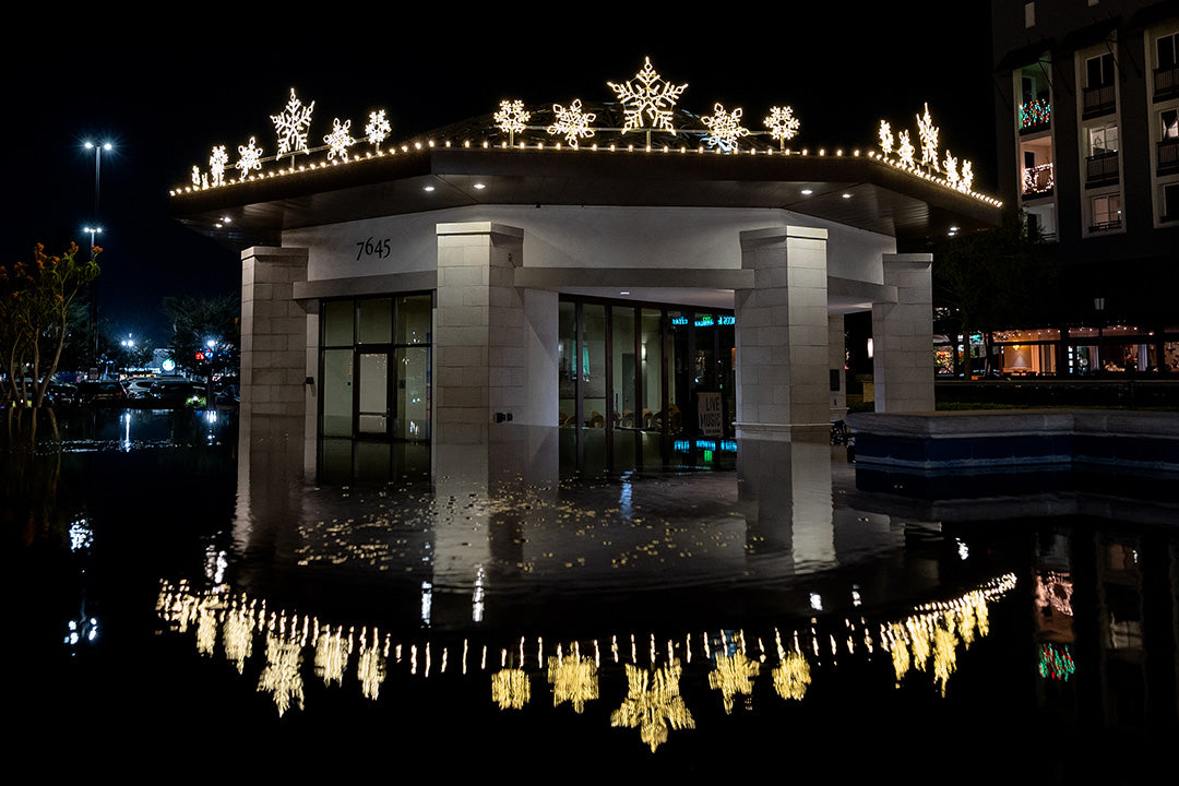 A brightly lit building with snowflake decorations on the roof, casting a warm glow on the surrounding area.