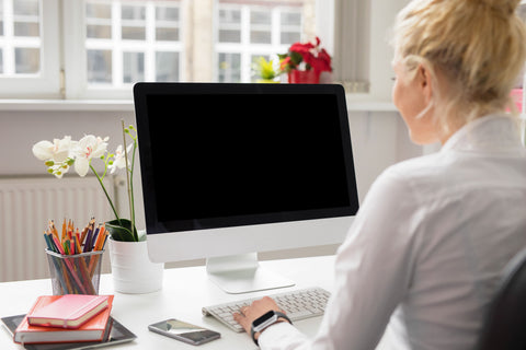 woman sitting and Mac desktop