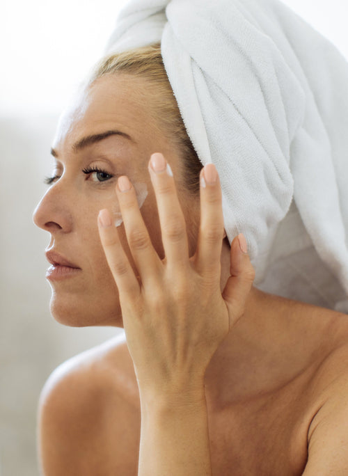 women applying restore cream on her face