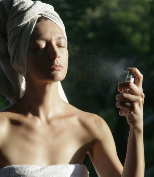 Lady spraying toner on his face