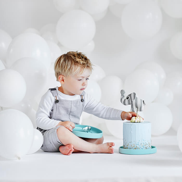 Boy eating cake with silicone plate in blue from Done by Deer