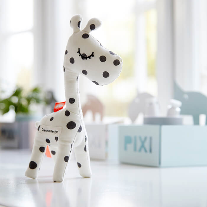 Done by Deer Raffi giraffe toy in white with black dots 