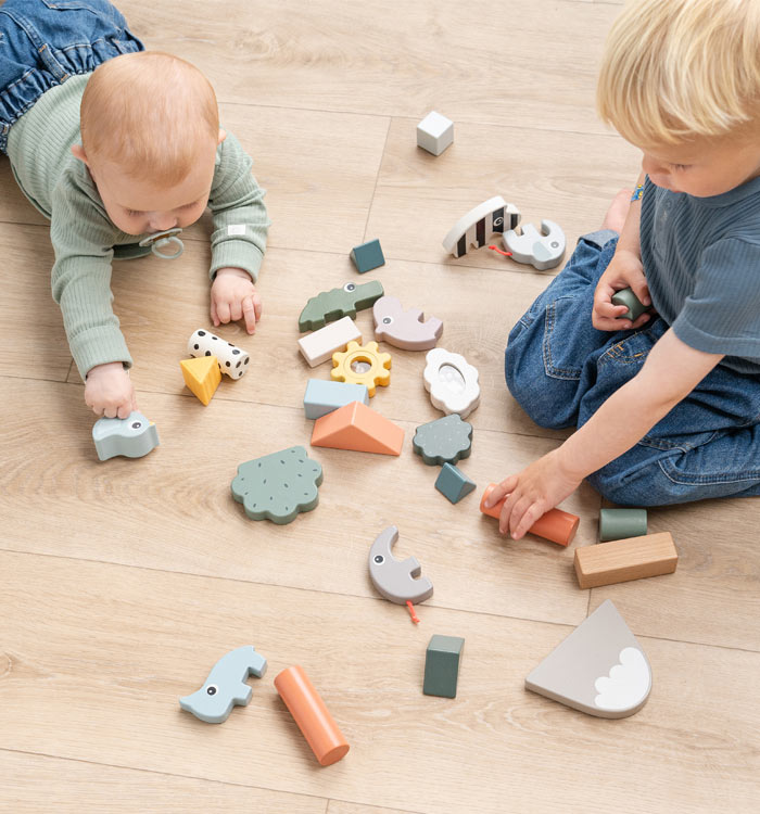 Baby and boy playing with wooden building blocks