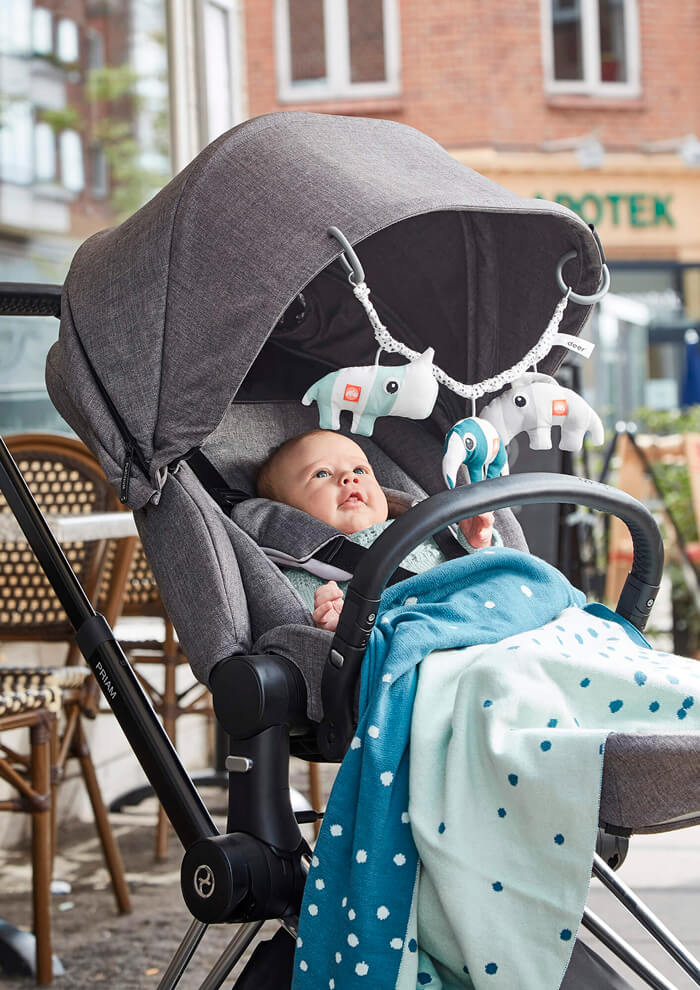 Kid in stroller with pram chain with toys from Done by Deer