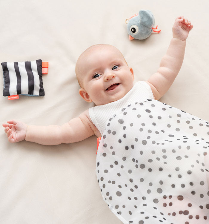 baby playing with a black and white dotted scarf