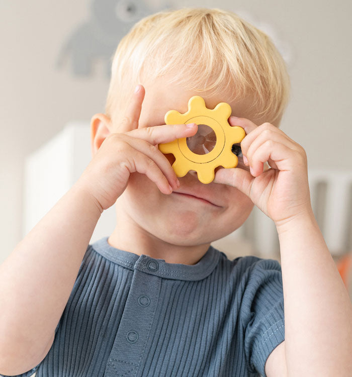 Boy looking into a kalaidoscopic lense from Done by Deer building block set