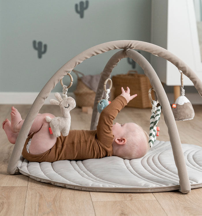 Baby plying in a Done by Deer activity play mat