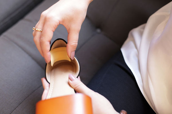 Woman putting back of heel cushion in shoe