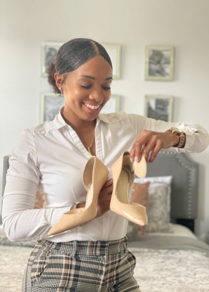 Women placing back of heel cushions in nude heels