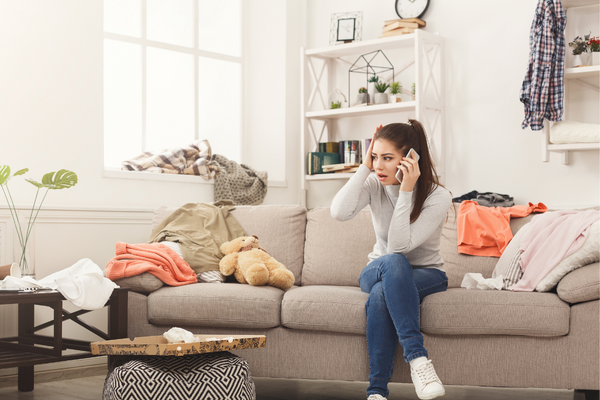 Stressed woman on phone and surrounded by clutter