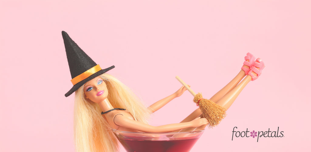 Barbie doll wearing a witch hat while sitting in a cocktail glass