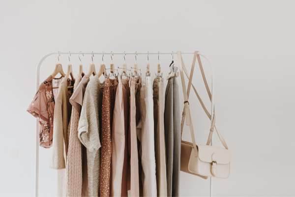 Neutral colored minimalist clothing and purses on a rack