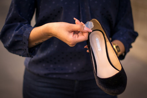 Woman holding heel and gel spot dot cushion