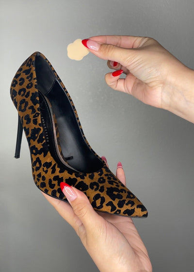 Woman placing spot cushion inside leopard print high heel