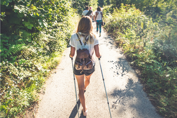 Woman on hiking trail with trekking poles