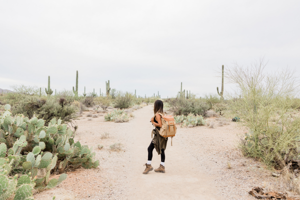 Woman standing in desert wearing summer hiking outfit