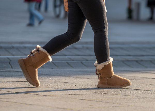 Person wearing shearling boots walking on street