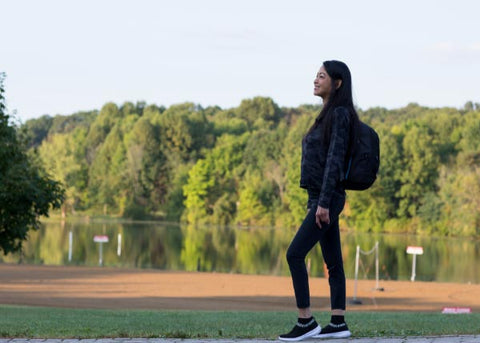 Woman walking at the park, green trees and green grass