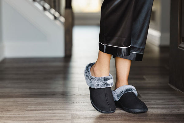 Woman wearing black PowerStep orthotic slippers