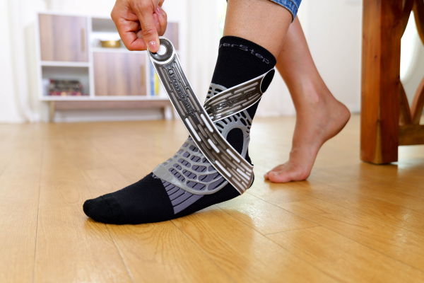 woman pulling strap over top of ankle brace sock