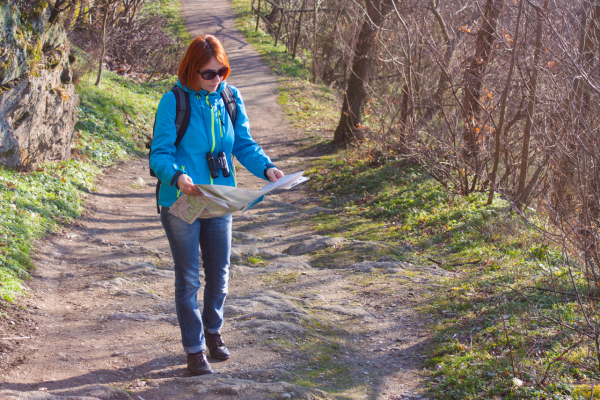 Woman looking at map on hiking trail