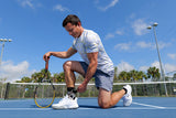 Man on tennis court, adjusting PowerStep Dynamic Ankle Support Sock