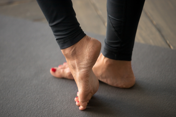 Woman standing with heel raised on toes on floor