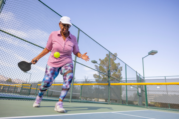 Senior woman playing pickleball outside