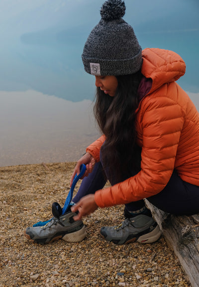 Woman putting blue PowerStep insole into hiking shoe