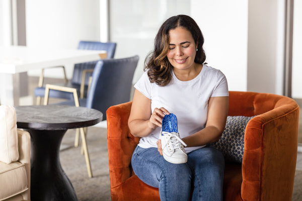 Woman placing shoe insole for back pain in white shoe