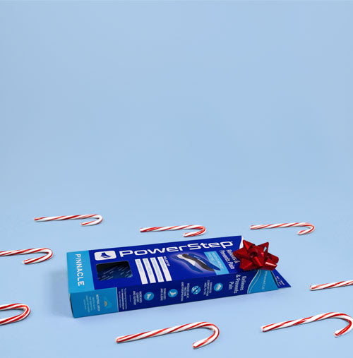 Box of PowerStep orthotic insoles surrounded by candy canes